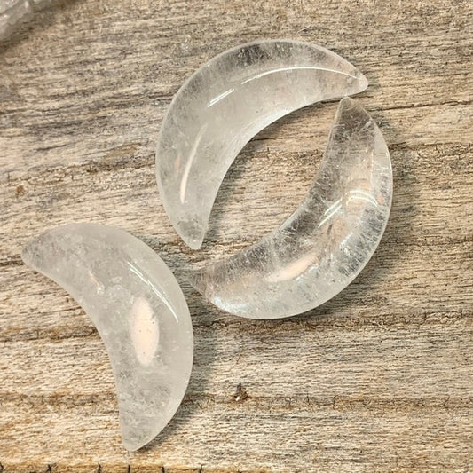 Clear quartz crescent moon cabochon capturing the beauty of celestial elegance in a mesmerizing crystal form.