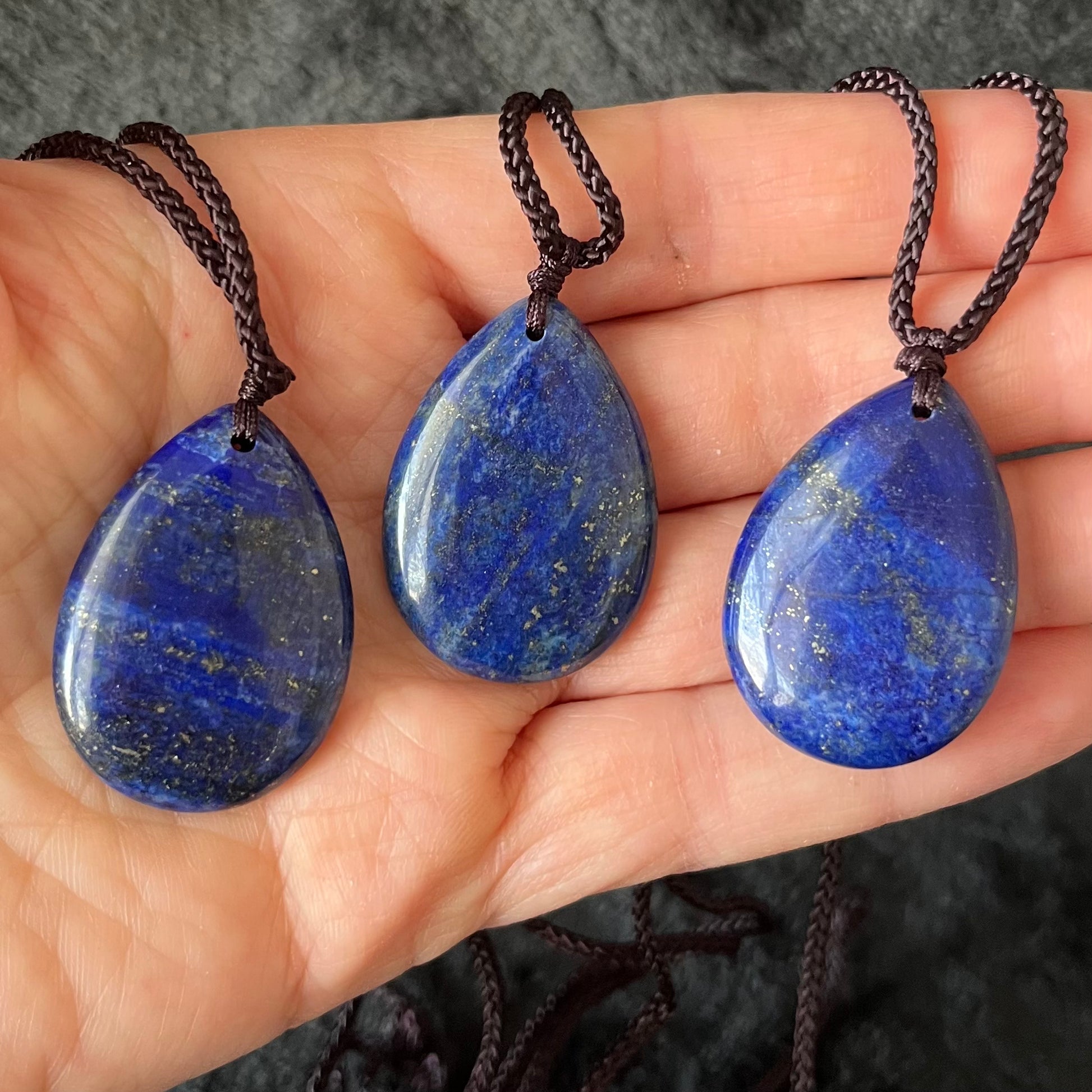 3 Exquisite lapis lazuli tear drop pendant necklaces, featuring deep blue gemstones suspended delicately from adjustable cords, adding elegance to any ensemble."