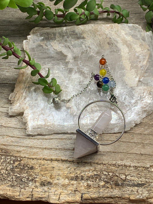 2 in pendulum including rose quartz inverted pyramid attached to rose quartz crystal point in a silver hoop, connected to an 8 inch chain including chakra beads