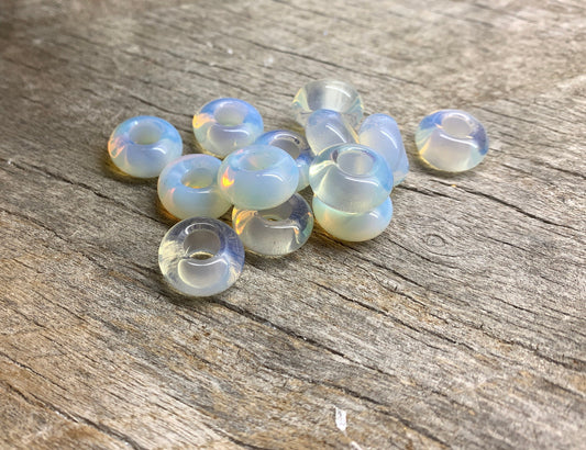 "Close-up view of lustrous 14mm Opalite beads, exhibiting a soothing iridescent play of colors in shades of milky blue and pink.