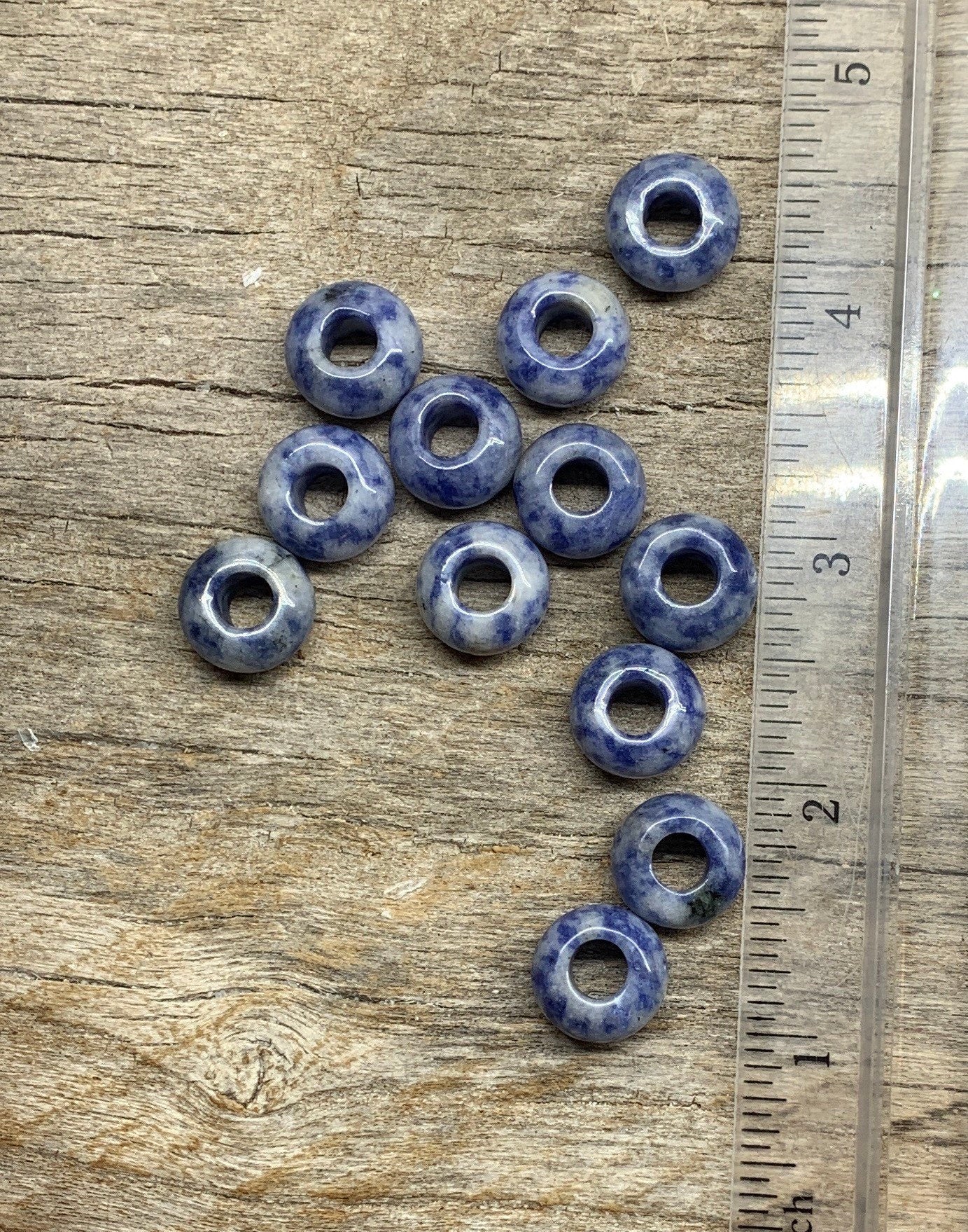 "Close-up of vibrant 14mm Sodalite beads, showcasing their rich blue hues and natural patterns, positioned next to a ruler to show size
