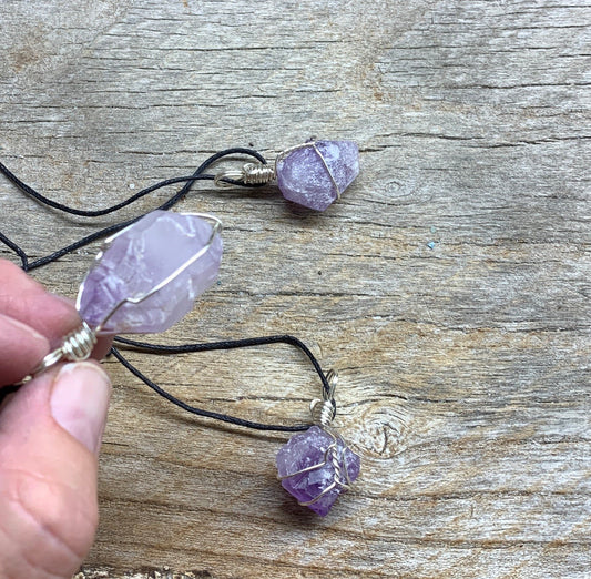 3 silver wire wrapped, transluacent purple amethyst pendants, attatched to adjustable black cords, between 1/2 to 1 inch in length.  