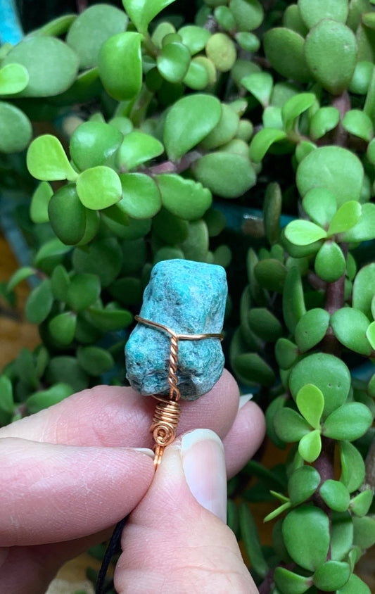 Copper wire wrapped turquoise nugget pendant, approximately 1" long, attatched to an adjustable black cord