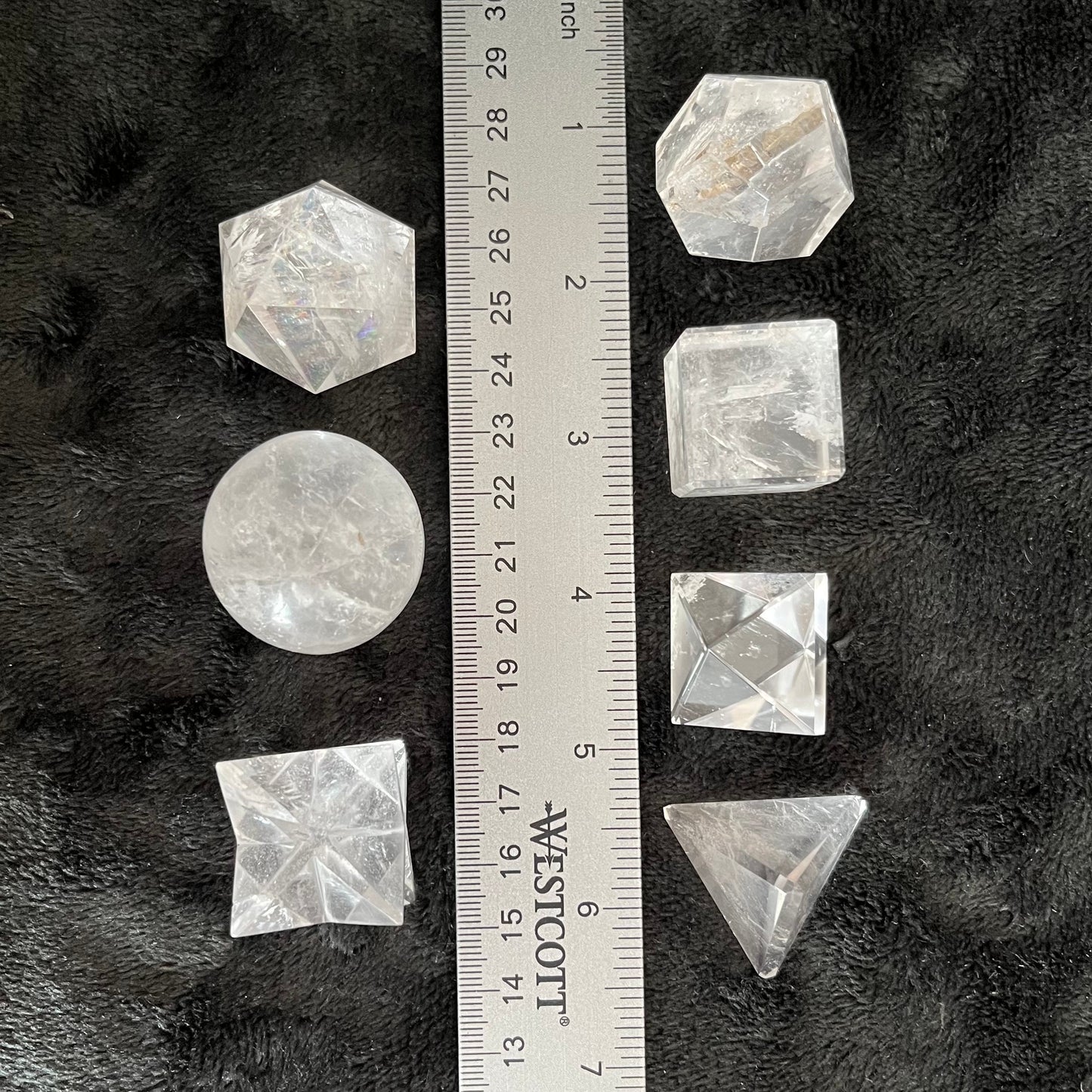 Seven quartz crystals, forming sacred geometric patterns with intricate symmetry, reflecting the beauty and harmony of sacred geometry in natural quartz formations, displayed next to ruler. Quartz crystals are approximately 1” in diameter.