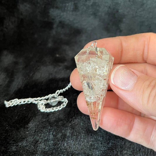 Quartz organite pendulum featuring a clear quartz crystal suspended in resin, designed for divination and energy work.