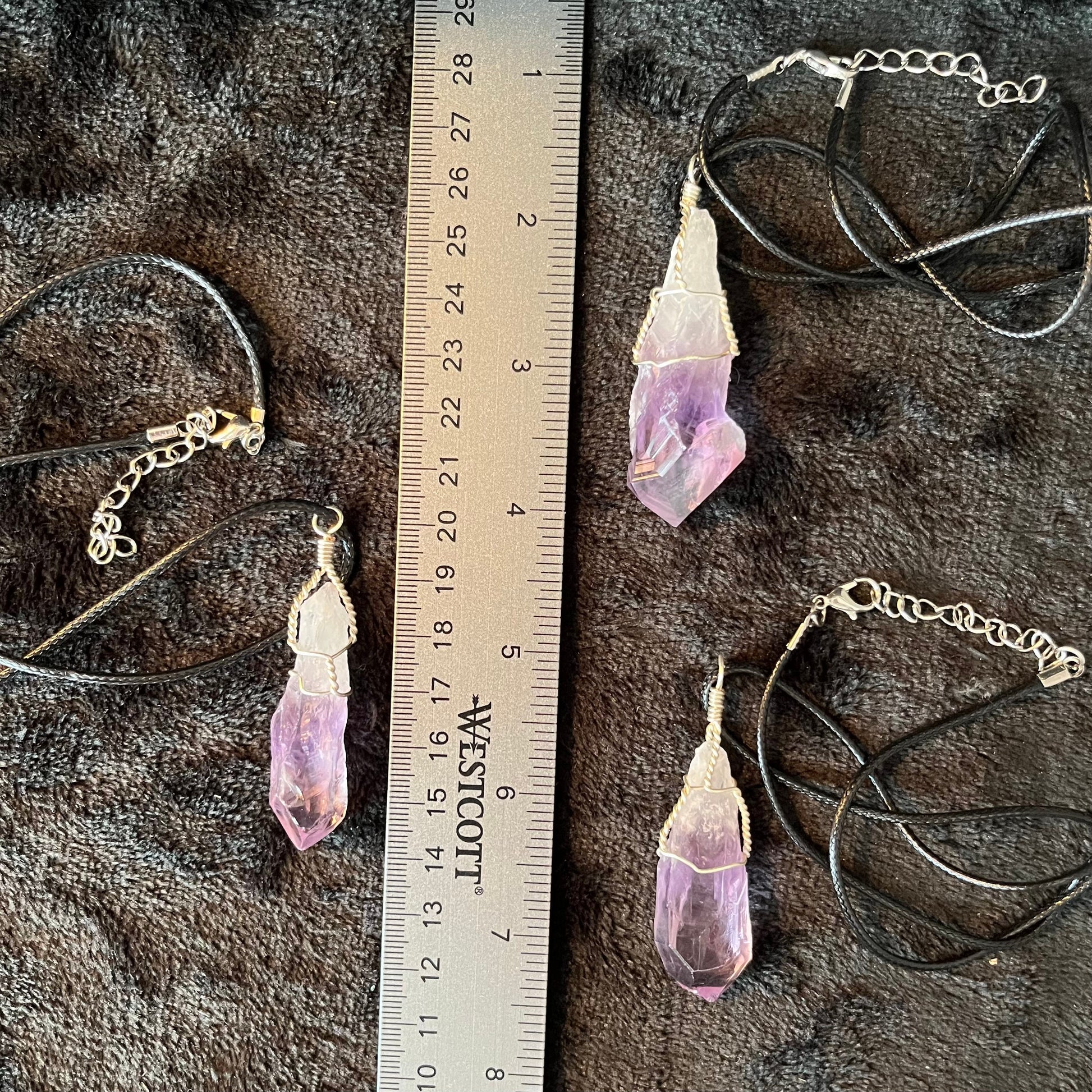 3 dragon's tooth amethyst, silver wire wrapped necklace, displayed next to a ruler to show size.  pendants are 2 3/4 inches to 3 1/4 inches long attatched to adjustable cords