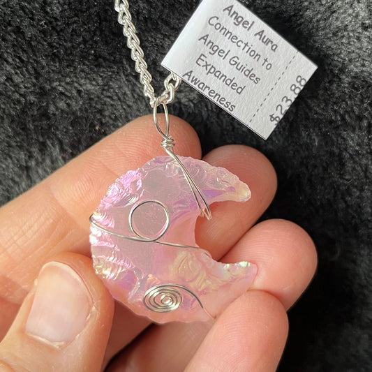 shimmery mettallic lookong ponk angel aura pink opalite, knappes creacent moon ornately silver wire wrapped pendant attatched to a silver chain.