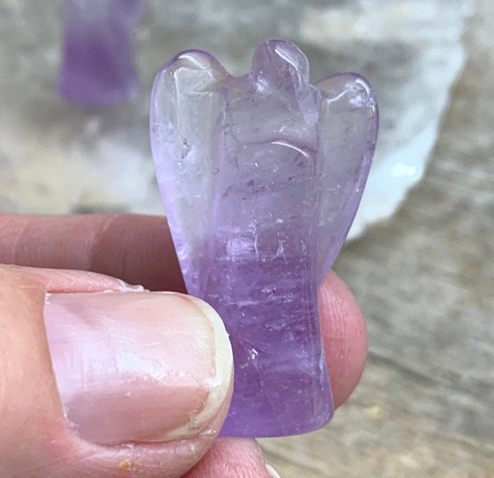 Small amethyst angel carving, featuring a serene and detailed design in translucent purple hues, capturing the essence of spiritual elegance.