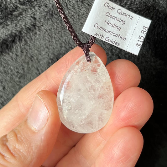 Quartz teardrop pendant with intricate facets, showcasing a mesmerizing crystal clear elegance, attached to an adjustable brown cord