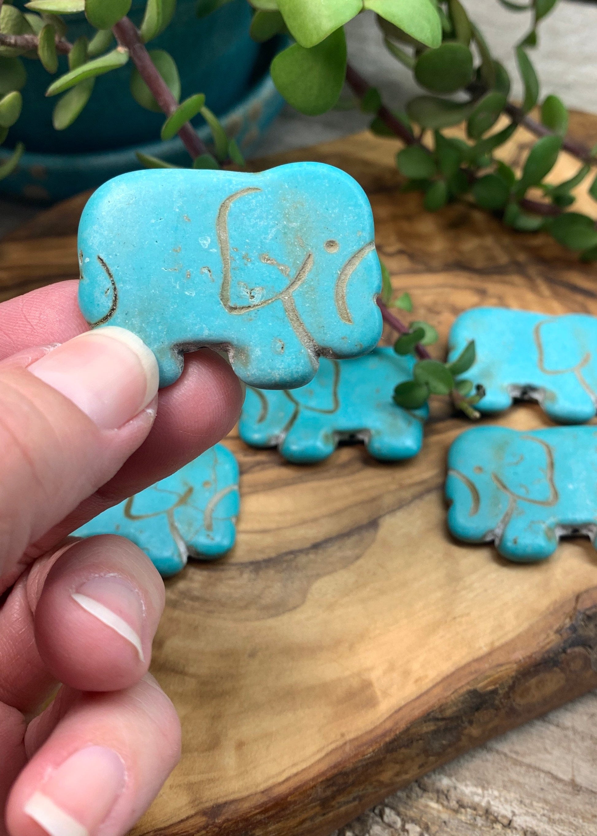 "Close-up of a vibrant blue Howlite elephant bead with intricate details.