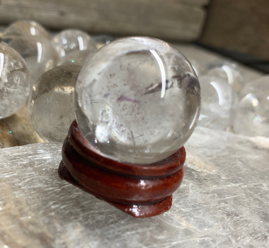 "Clear quartz sphere, 1" diameter: Transparent crystal sphere, perfect for divination or decorative use, displayed on a sphere stand.