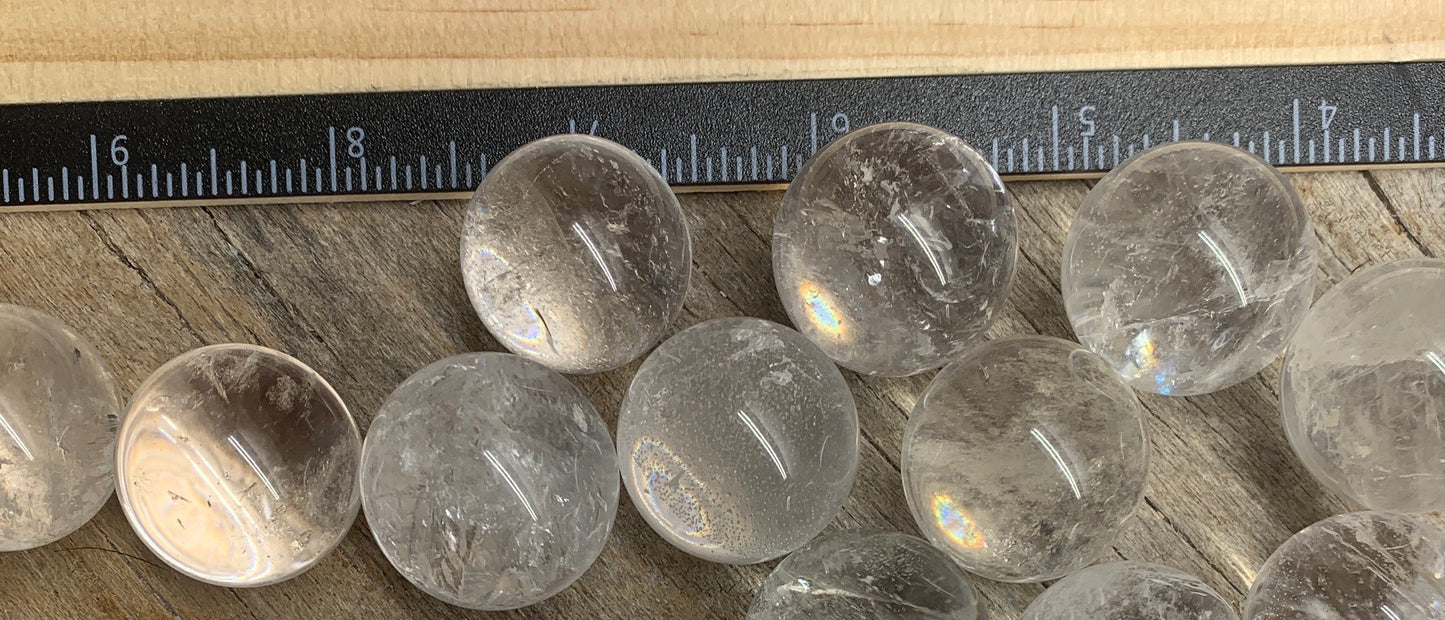 Clear quartz spheres, 1" diameter: Transparent crystal spheres, perfect for divination or decorative use, displayed next to a ruler.