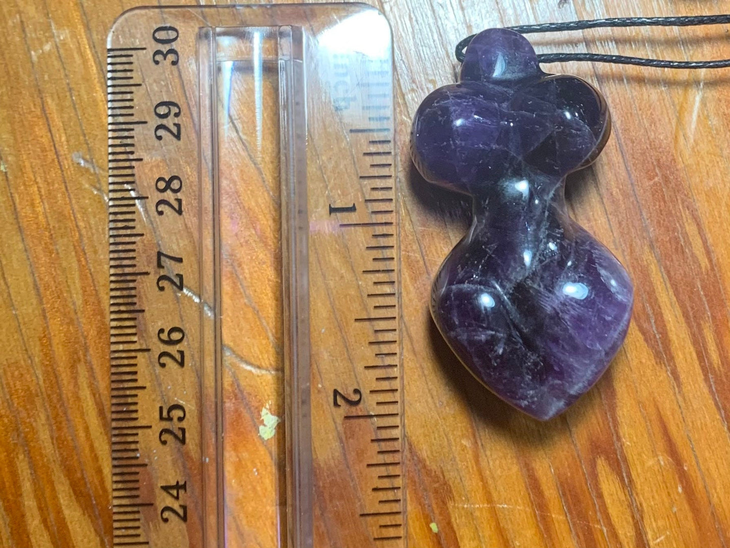 Gorgeous amethyst goddess bodice pendant necklace, embodying regal charm and mystical allure, displayed next to a ruler to show size.  Amethyst pendant is approximately 2” long.