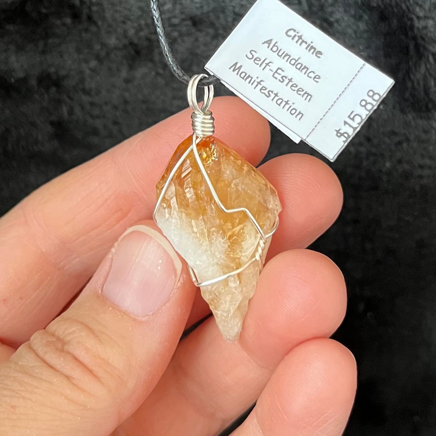 golden yellow translucent citrine crystal, solver wire wrapped  and attatched to an adjistable black cord.  pendant is approximately 1 inch long