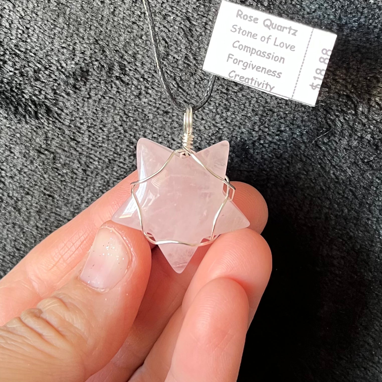 Handcrafted rose quartz star wire wrapped necklace, showcasing the delicate beauty of natural gemstones and skilled craftsmanship.  pendant is approximately 1" long and  attarched to an adjustable black cord.