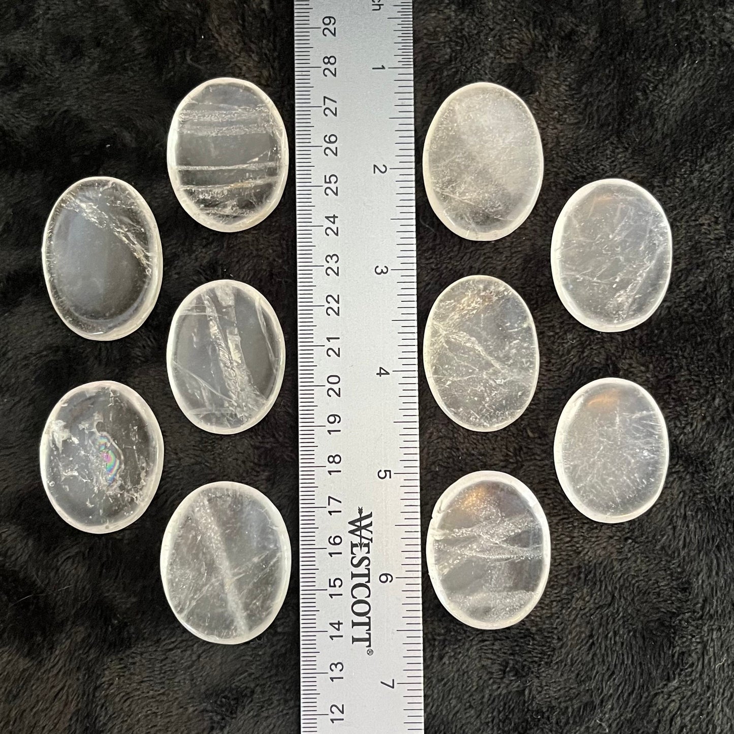 Smooth, translucent quartz worry stones – perfect for calming anxiety and promoting relaxation through tactile sensation, displayed next to a ruler to show size