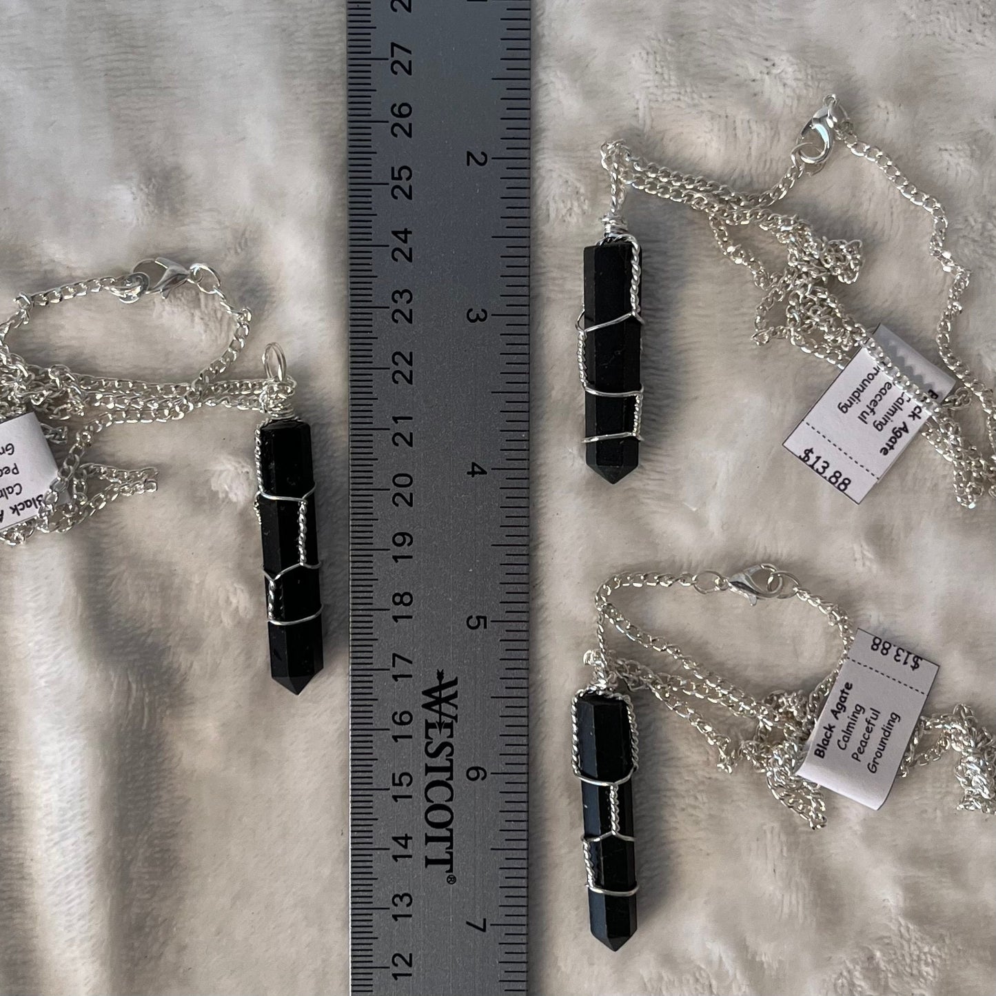 3, 1 1/2" black agate crystal point, handmade, silver wire-wrapped pendant attached to 20 inch silver chains, displayes next to a ruler.