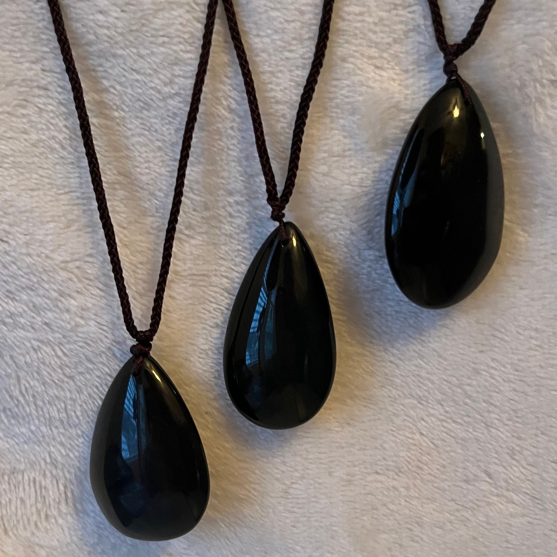 3 Iridescent rainbow obsidian tear drop pendant necklaces, showcasing a spectrum of captivating hues, gracefully hung from adjustable cords for a touch of mystical beauty."