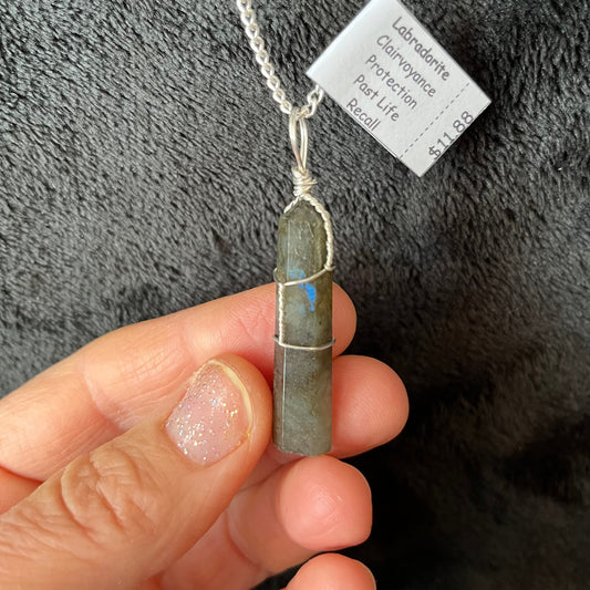 Silver Wire Wrapped Labradorite Point Pendant attatched to a silver chain.  stone is approximately 3/4" long